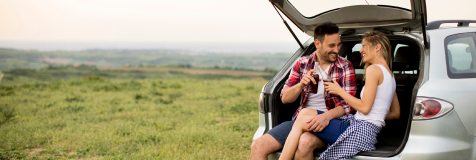Pareja amorosa sentanda en el baúl del auto